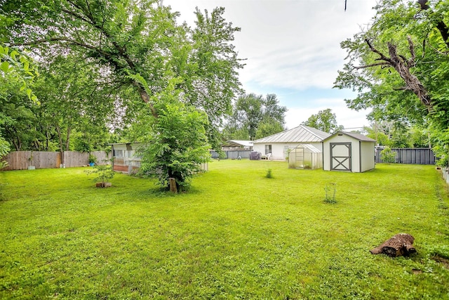 view of yard featuring an outdoor structure, a fenced backyard, an exterior structure, and a shed