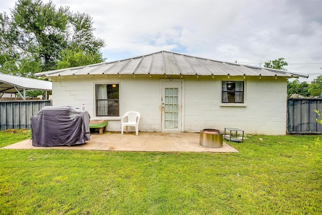 rear view of property with a patio, a fenced backyard, and concrete block siding