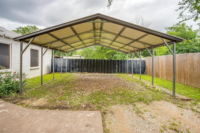 view of yard with a fenced backyard, a detached carport, and driveway