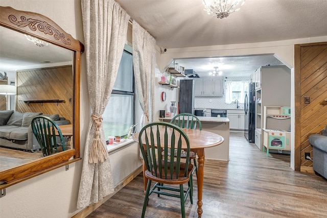 dining room with wood finished floors and a chandelier