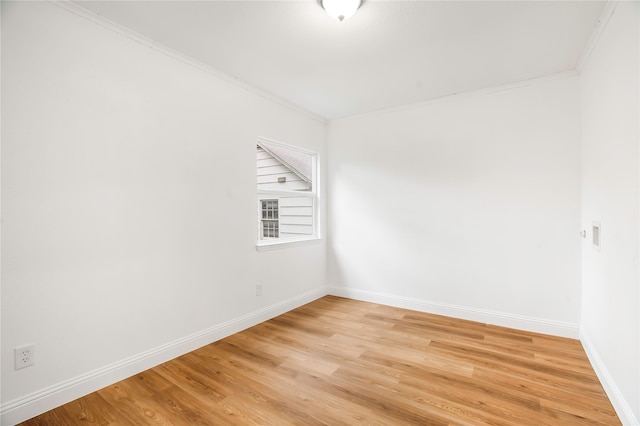 unfurnished room featuring light wood-style floors, baseboards, and ornamental molding