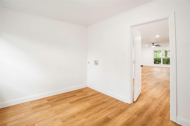 unfurnished room featuring crown molding, baseboards, ceiling fan, and light wood-type flooring