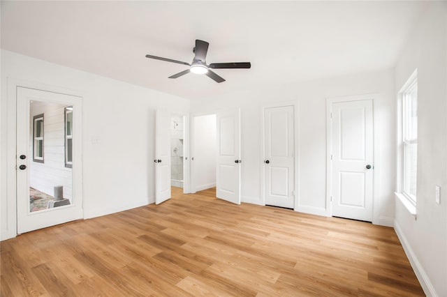 unfurnished bedroom featuring baseboards, multiple windows, and light wood-style floors