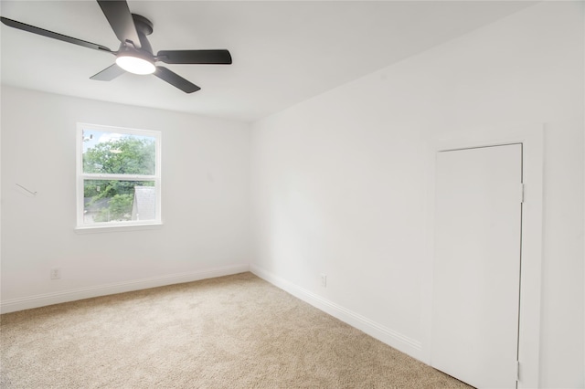 spare room featuring baseboards, ceiling fan, and light carpet