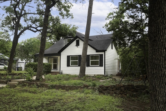 view of side of home with roof with shingles