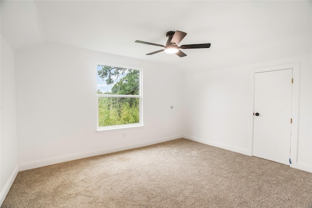 carpeted empty room with baseboards, a ceiling fan, and vaulted ceiling