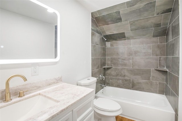 bathroom featuring washtub / shower combination, vanity, and toilet