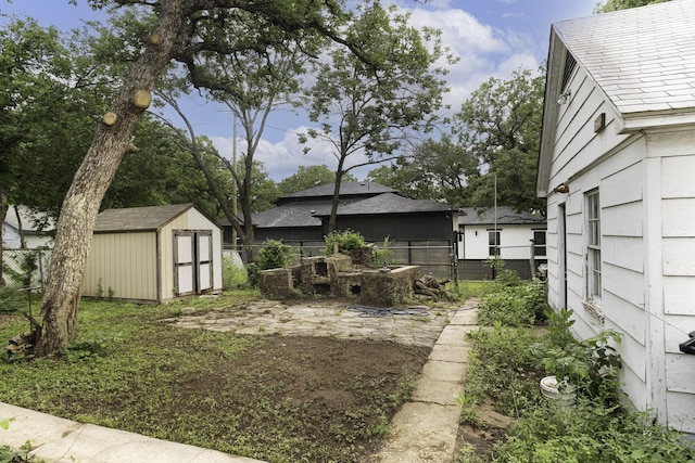 view of yard with a storage unit, an outdoor structure, and fence