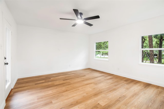 empty room featuring baseboards, light wood-style flooring, and ceiling fan
