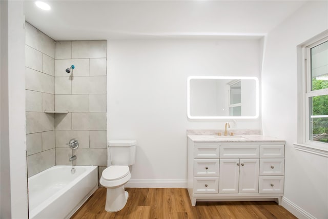 bathroom featuring toilet, baseboards, wood finished floors, and vanity