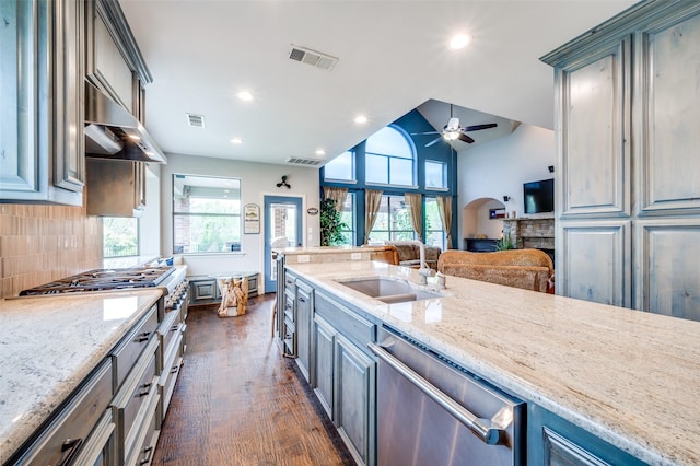 kitchen featuring a stone fireplace, a ceiling fan, appliances with stainless steel finishes, and visible vents