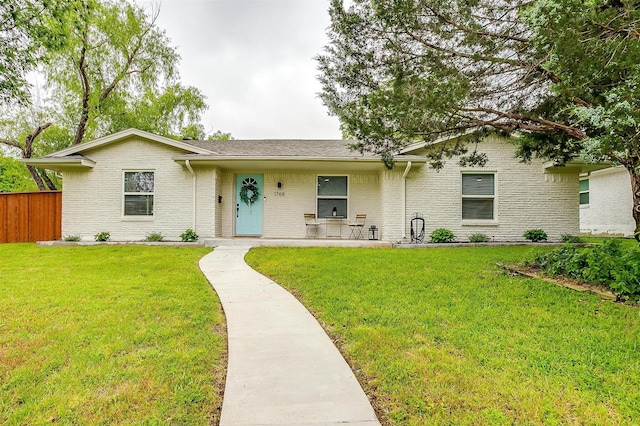 ranch-style house featuring brick siding, fence, and a front yard