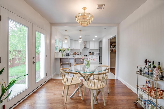 dining space featuring plenty of natural light, wood finished floors, and visible vents