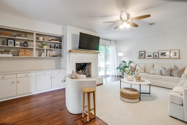 living area with visible vents, a ceiling fan, dark wood-type flooring, and a fireplace