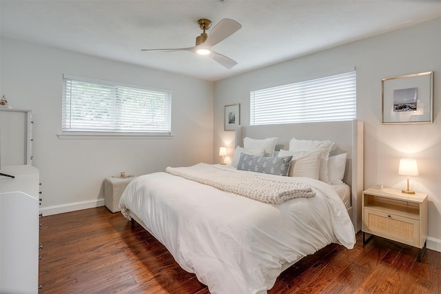 bedroom featuring baseboards, multiple windows, a ceiling fan, and wood finished floors