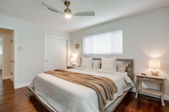 bedroom with visible vents, a closet, wood finished floors, baseboards, and ceiling fan