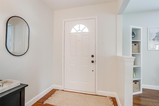 entryway with baseboards and wood finished floors