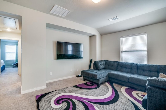 living area featuring carpet floors, baseboards, visible vents, and vaulted ceiling