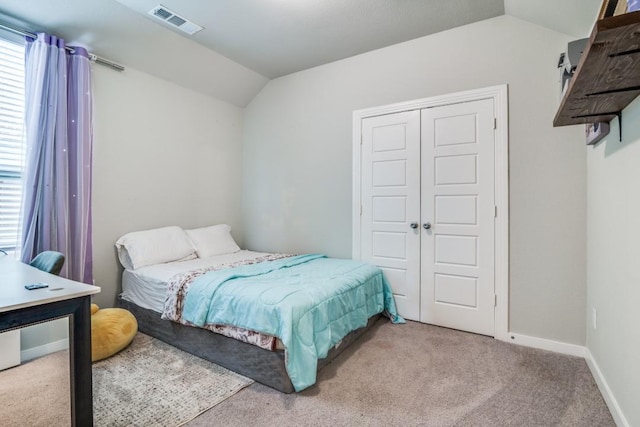 bedroom with carpet flooring, visible vents, baseboards, vaulted ceiling, and a closet