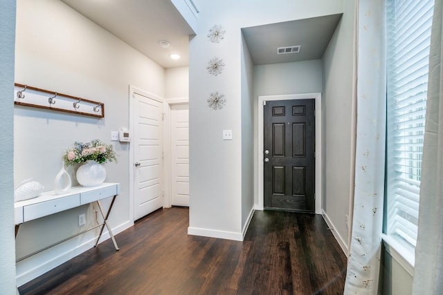 foyer with baseboards, visible vents, and wood finished floors