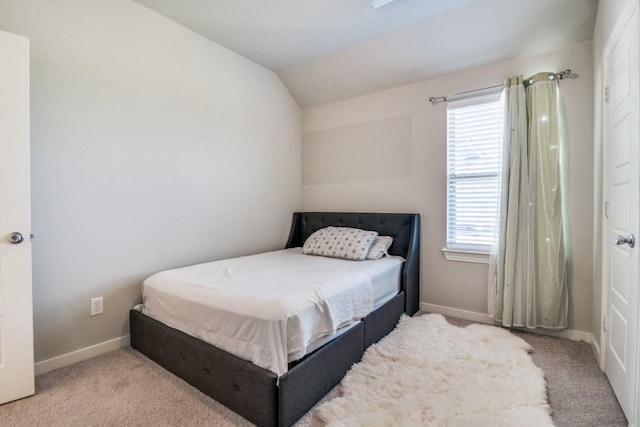 bedroom with carpet floors, baseboards, vaulted ceiling, and multiple windows