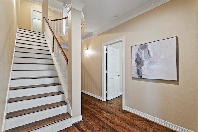 staircase featuring baseboards, ornamental molding, and wood finished floors