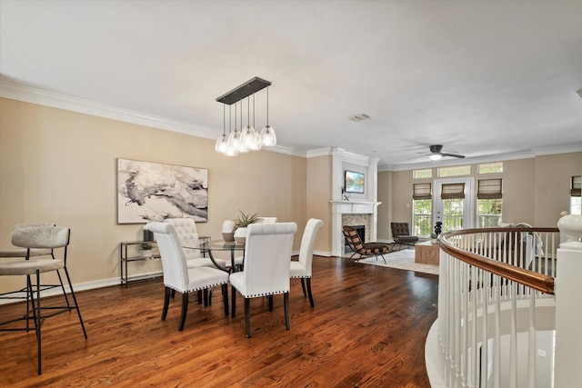 dining area featuring ornamental molding, dark wood-style floors, and a fireplace