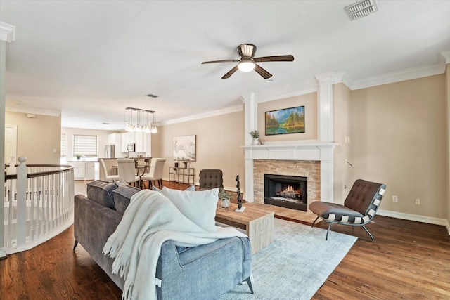 living room featuring a ceiling fan, visible vents, and ornamental molding