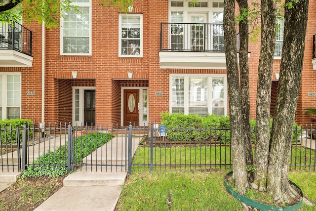 exterior space with brick siding, a gate, and fence