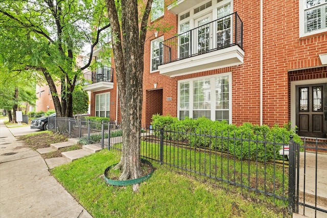 property entrance with fence and brick siding