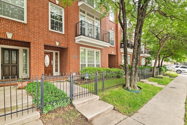 view of front of home featuring brick siding, a gate, and a fenced front yard