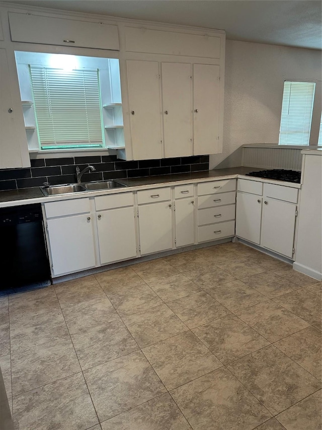 630 W College St, Stephenville, TX 76401 - kitchen featuring black dishwasher, a sink, open shelves, and white cabinets