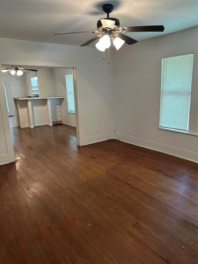 630 W College St, Stephenville, TX 76401 - empty room with a ceiling fan, dark wood-type flooring, and baseboards