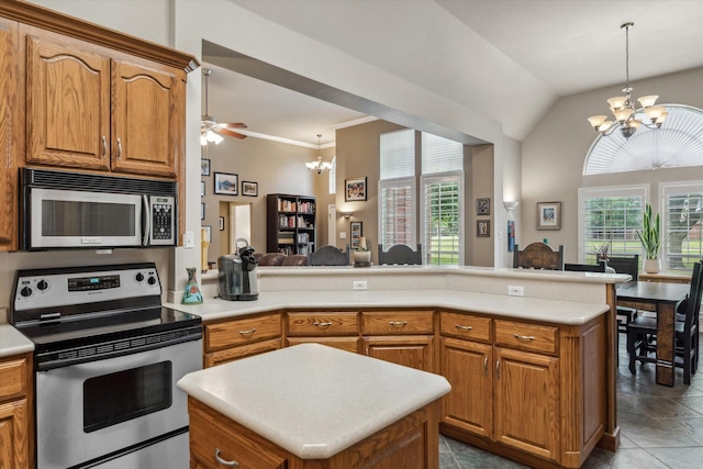 kitchen featuring appliances with stainless steel finishes, light countertops, brown cabinetry, a peninsula, and decorative light fixtures