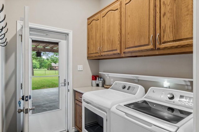 clothes washing area featuring cabinet space and washer and dryer