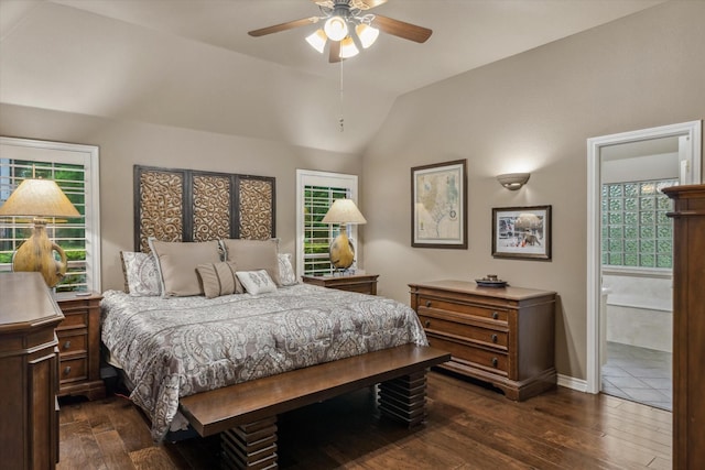 bedroom featuring baseboards, vaulted ceiling, dark wood-style floors, and ensuite bath