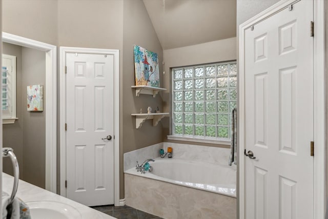 bathroom with tile patterned floors, a bath, and vaulted ceiling
