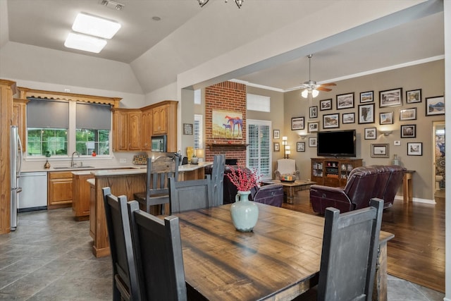dining space featuring visible vents, lofted ceiling, a fireplace, baseboards, and ceiling fan