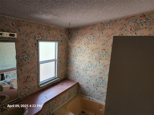 full bathroom with a textured ceiling, wallpapered walls, and a bath