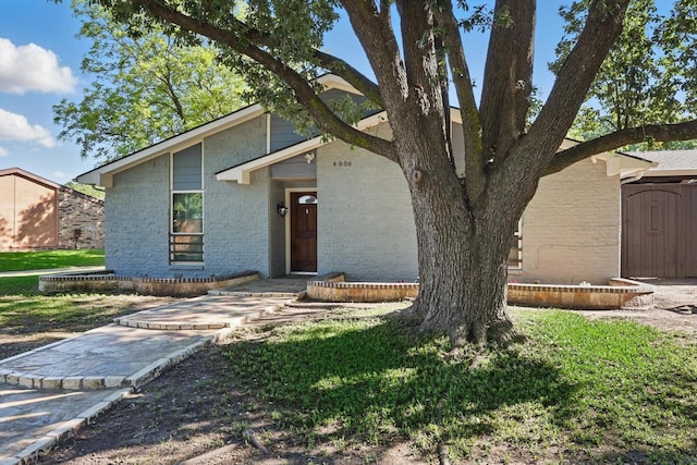 4006 Mayflower Dr, Garland, TX 75043 - mid-century modern home with brick siding, a front yard, and a shed