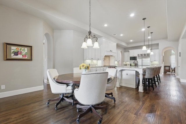 dining room with visible vents, dark wood-style flooring, baseboards, recessed lighting, and arched walkways