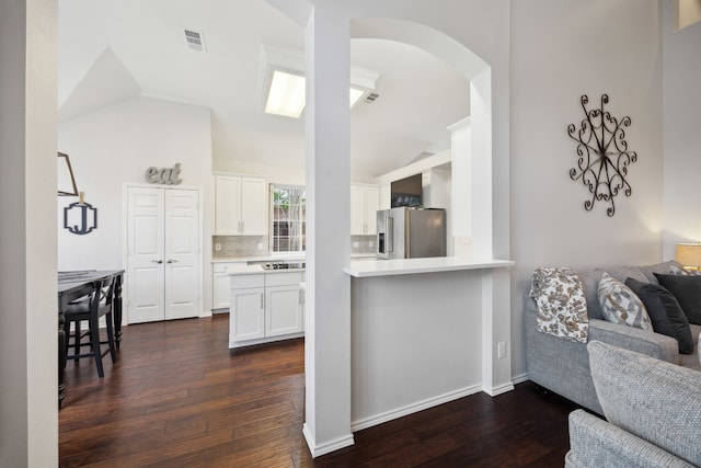 kitchen with visible vents, open floor plan, dark wood-style floors, stainless steel refrigerator with ice dispenser, and white cabinets