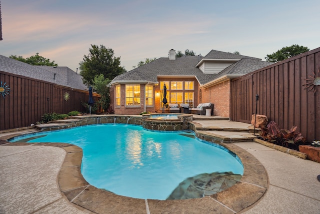 view of pool with a pool with connected hot tub, outdoor lounge area, a fenced backyard, and a patio area