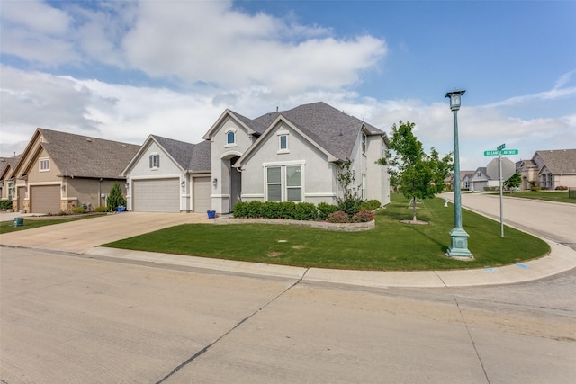 view of front of home with a garage, a front lawn, concrete driveway, a shingled roof, and stucco siding