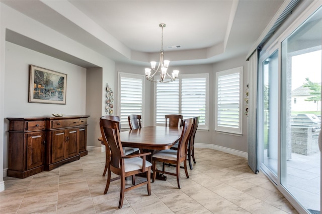 dining room featuring visible vents, baseboards, a tray ceiling, and a notable chandelier