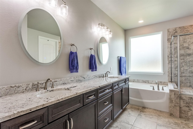 full bath featuring a sink, double vanity, a shower stall, and a bath
