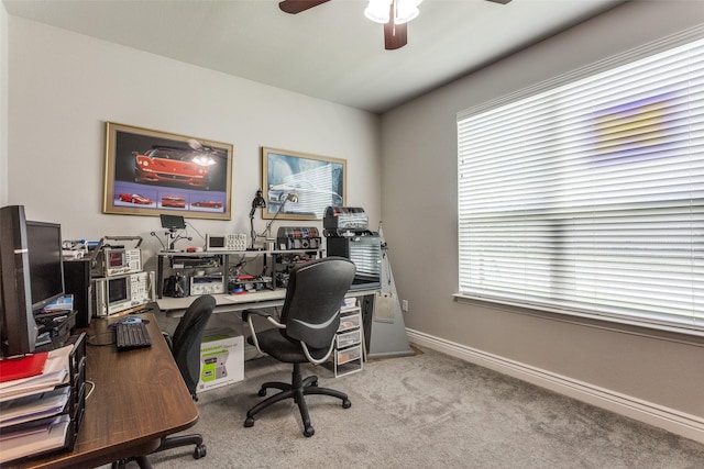 carpeted home office featuring baseboards and ceiling fan