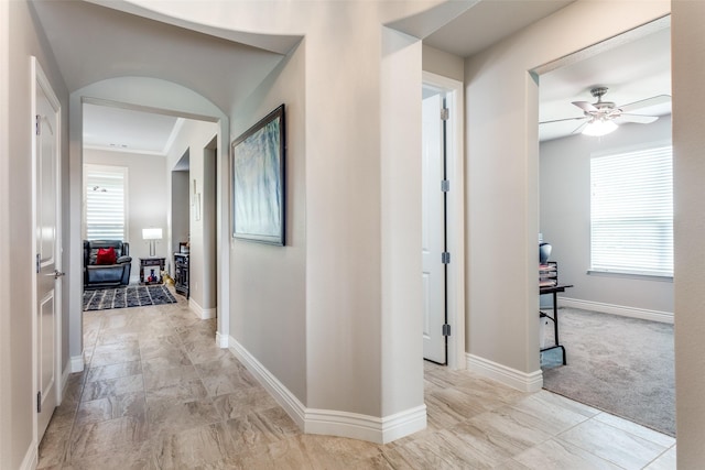 corridor with baseboards and a wealth of natural light