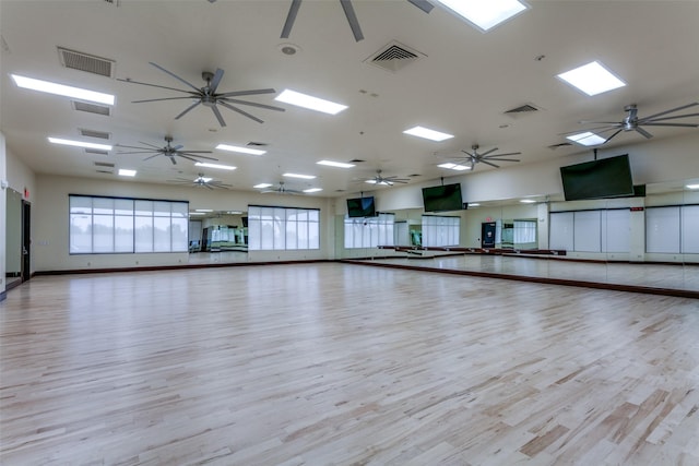 exercise room with a ceiling fan, wood finished floors, and visible vents