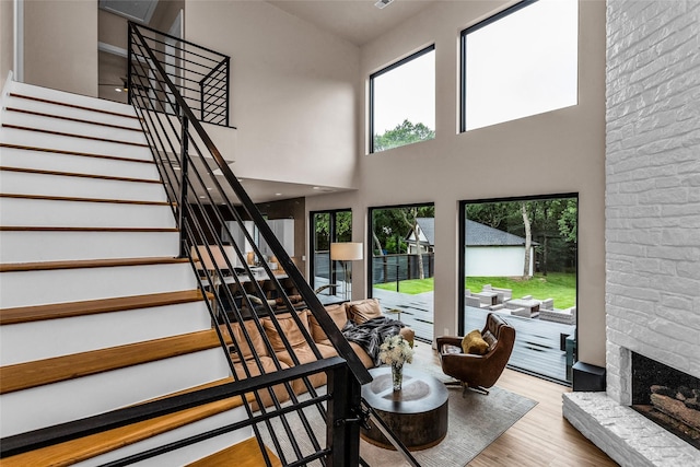 2856 Peninsula Dr, Grapevine, TX 76051 - stairway featuring a fireplace, wood finished floors, and a towering ceiling